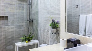 A modern bathroom with a shower, a toilet, a sink with a mirror, and a small plant on the counter. - Cozy 1BR 1 Min Walk to Beach Pool BBQ Area (Punta Cana)