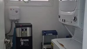 Un lavadero pequeño con calentador de agua, lavadora y secadora.