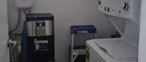 Una lavanderia funzionale con scaldabagno, lavatrice e asciugatrice.