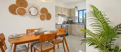 Una cocina moderna con armarios de madera, horno integrado y microondas.