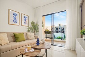 Een moderne woonkamer met een bank, een salontafel en twee ingelijste kunstwerken.