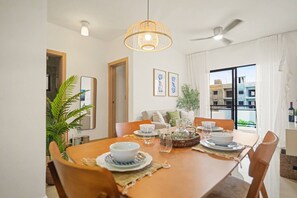 Een eetruimte met een tafel voor vier personen, een plafondventilator en uitzicht op het omliggende landschap.
