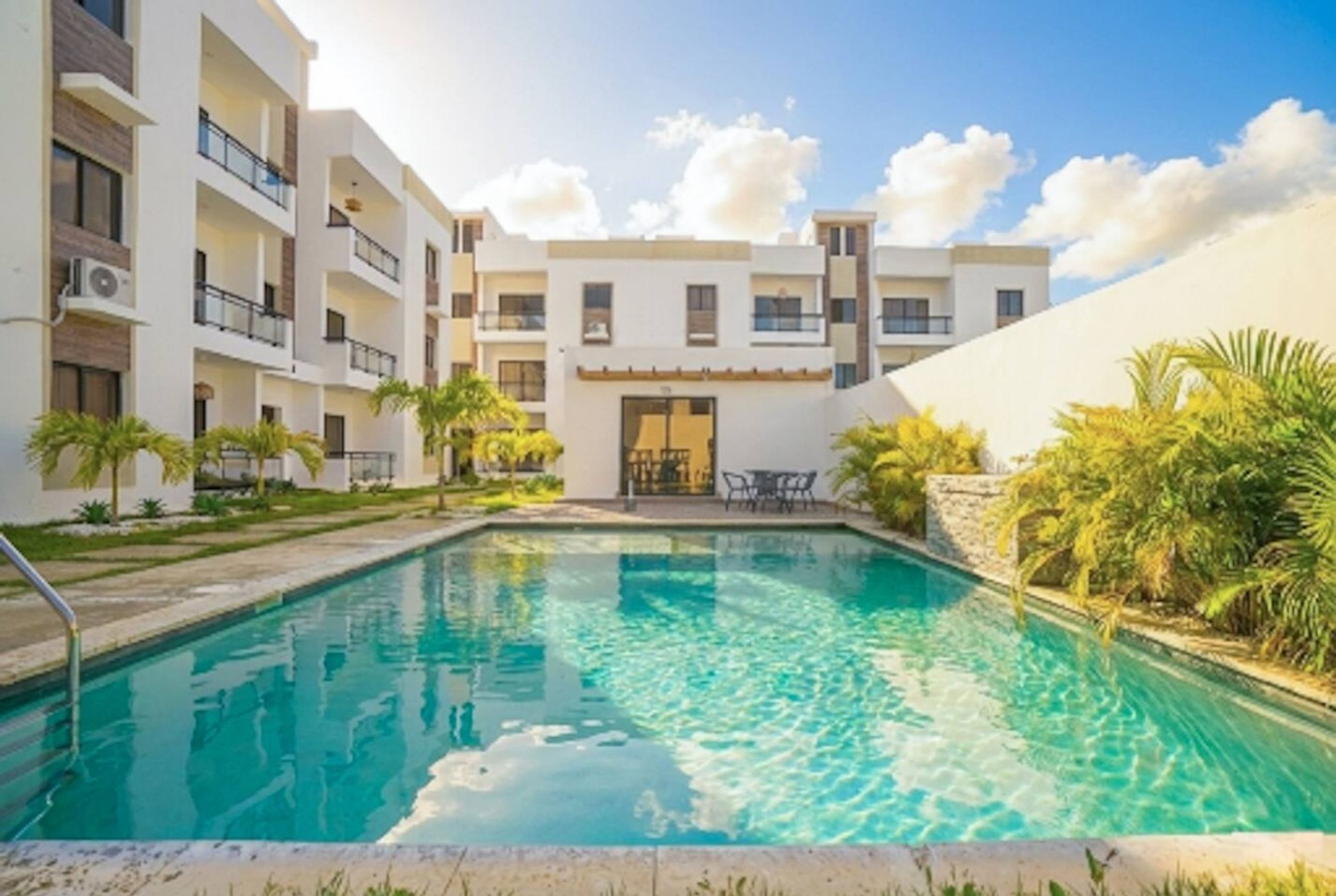 Un hôtel doté d’une piscine, de plusieurs balcons et offrant une vue sur un ciel dégagé.