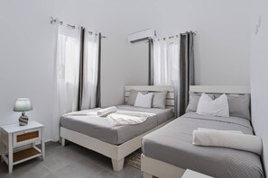 A hotel room with two single beds, a small bedside table with a lamp, and a window with curtains. - Spacious 3BR Home Pool Macao Beach (Punta Cana)