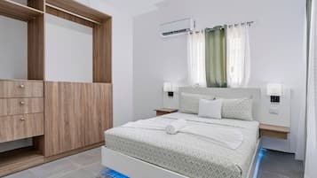Un dormitorio moderno con cama, armario, mesita de noche y aire acondicionado.