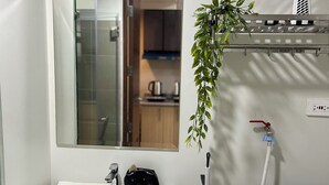 Ein Badezimmer mit Waschbecken, Spiegel und Pflanze.