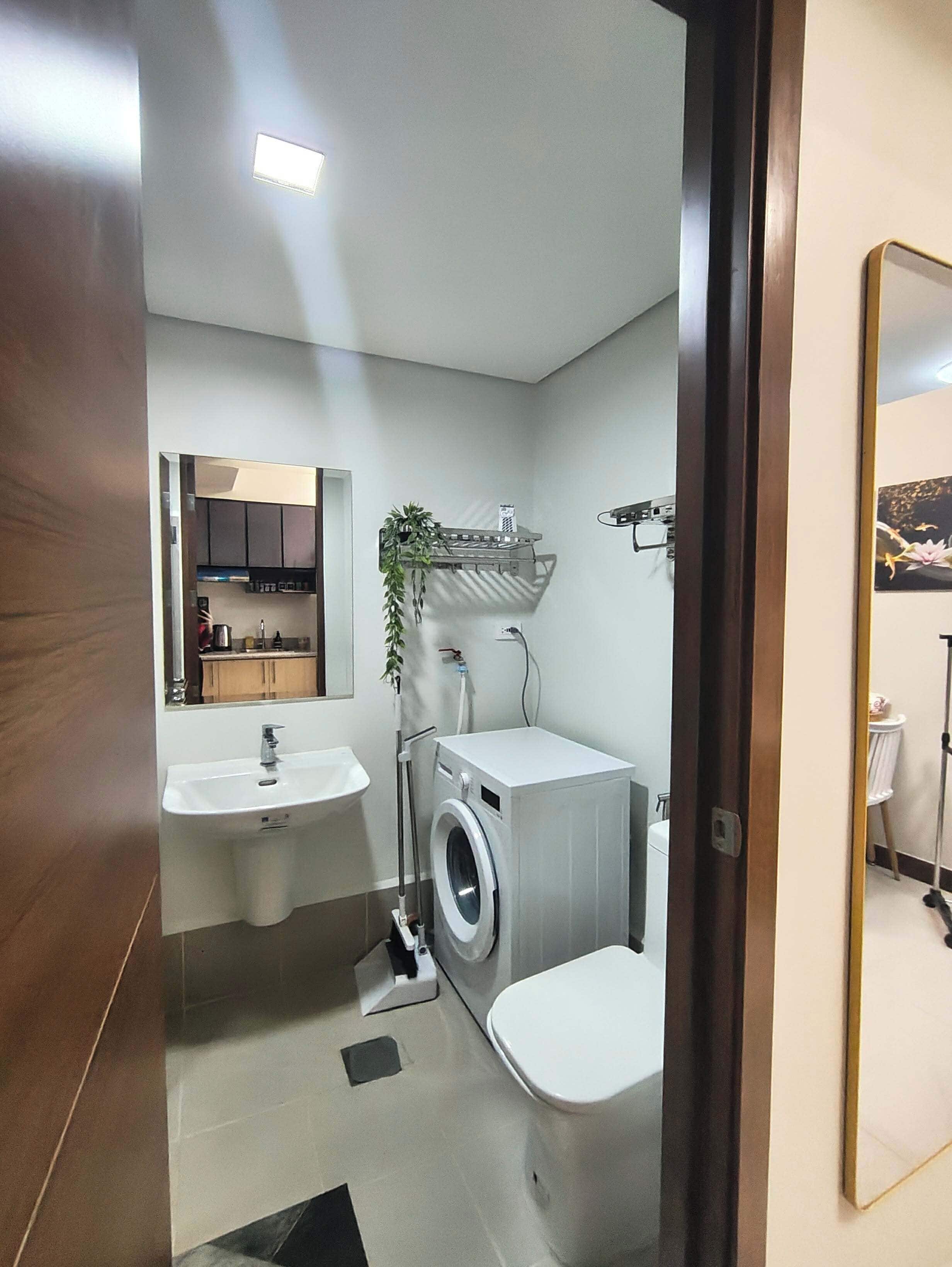 Une petite salle de bain comprenant un lavabo, des toilettes et un lave-linge.
