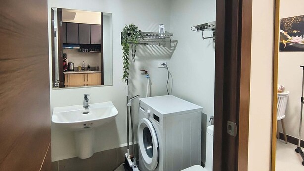Ein kleines Badezimmer mit Waschbecken, Toilette und Waschmaschine.