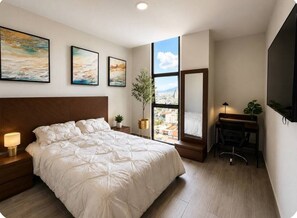 Una camera da letto con un letto grande, una scrivania, una sedia, una TV e una finestra vista città.