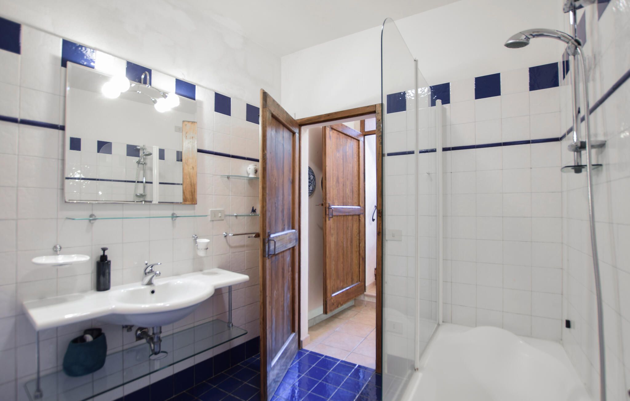 Une salle de bain avec deux lavabos, un miroir et une douche.