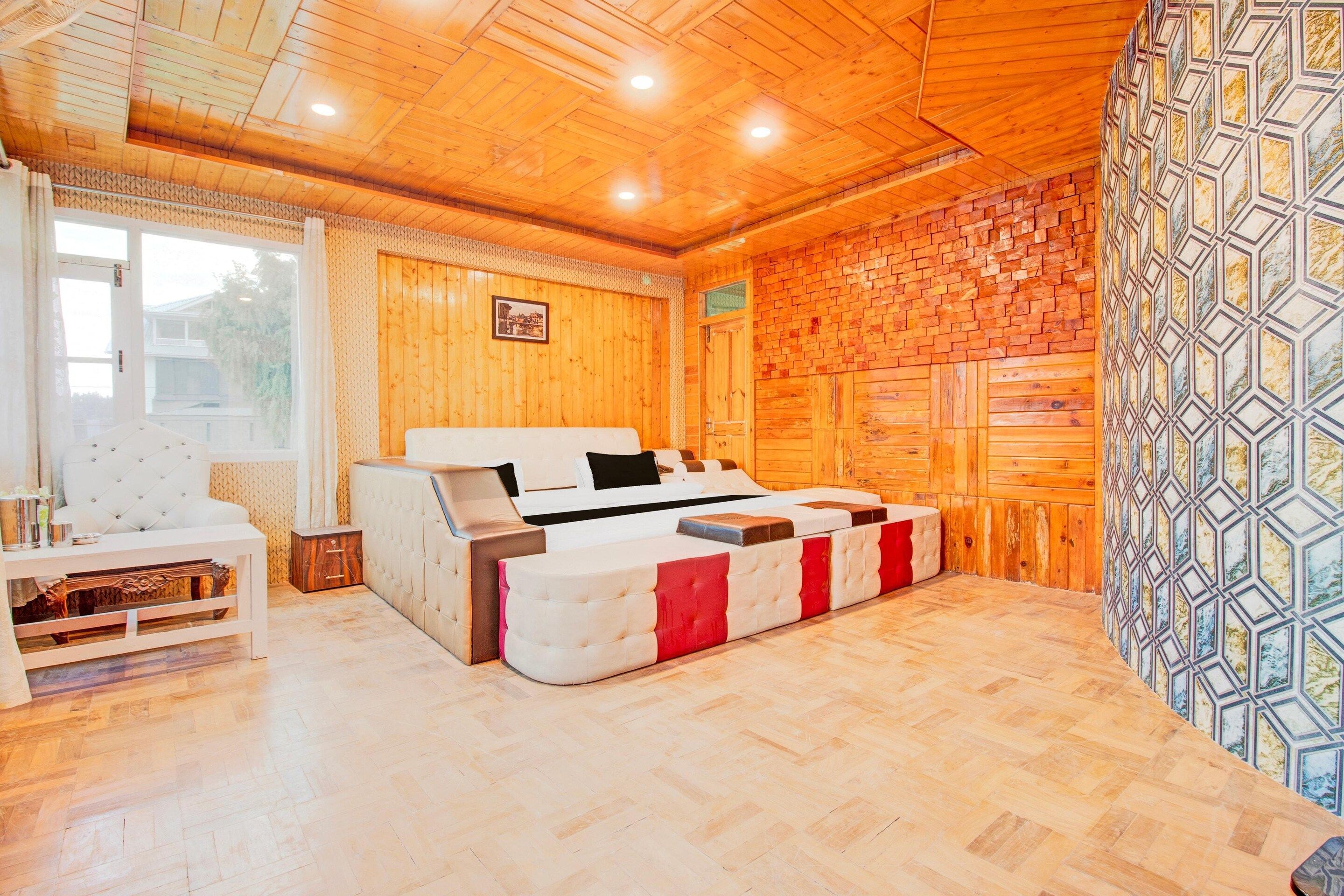 A room with a bed, a white sofa, a small table, and a patterned wall.