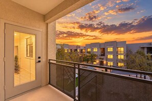 A balcony with a view of a modern building complex during sunset. - CozySuites Glendale - Westgate w pool! 1BR 1BA (Glendale)
