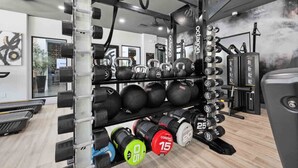 A gym with weightlifting equipment, including kettlebells, medicine balls, and dumbbells. - CozySuites Glendale - Westgate w pool! 2BR 2BA (Glendale)