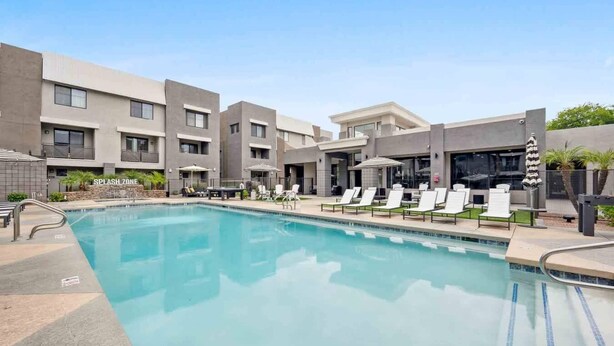 A modern hotel with a swimming pool, lounge chairs, and a 'Splash Zone' sign. - CozySuites Glendale - Westgate w pool! 2BR 2BA (Glendale)