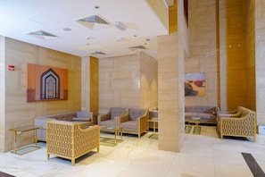 A modern lobby with seating areas, a reception desk, and a decorative wall. - Al Aseel Hotel Doha (Doha)
