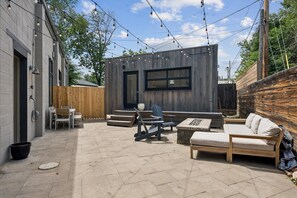 Eine Terrasse mit Gartenmöbeln, einer Holzterrasse und Lichterketten.