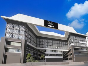 A modern building with a unique geometric facade and a prominent sign above the entrance.