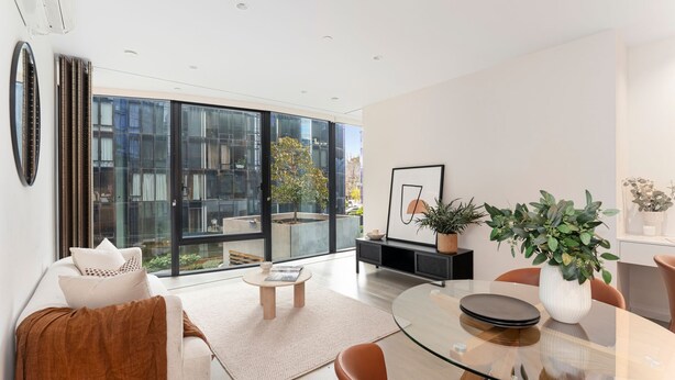 Sala moderna com mesa de centro de vidro, sofá e área de jantar com mesa de vidro.