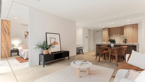 Uma sala moderna com sofá, mesa de centro e canto de jantar com cadeiras.