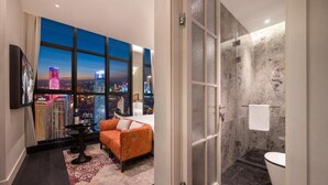 A modern bathroom with a shower, a toilet, and a large window with a cityscape view. - Kongshang  River view Hotel (Chongqing)