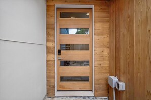 A wooden door with a sign that says 'PLEASE REMOVE YOUR SHEDS' and a keypad lock. - Modern 1BR: Reimagined Firehouse (Denver)
