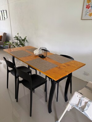 A dining table with four chairs, a decorative light fixture, and a potted plant. - Peaceful 2-bedroom house in charming Ulima, San Carlos, Alajuela Province (Alajuela Province)