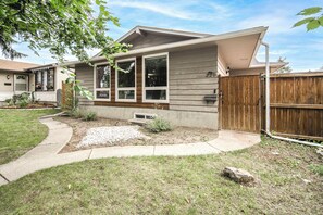 A residential house with a front yard, a wooden fence, and a driveway. - airport aside, park &shopping around Cozy 5 beds comfort home (Calgary)