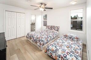 A bedroom with two beds, a ceiling fan, and a window with a view of the outside. - airport aside, park &shopping around Cozy 5 beds comfort home (Calgary)