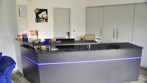 Ett modernt kontor med ett skrivbord, en dator och en stol. Det finns skåp och en anslagstavla på väggen.