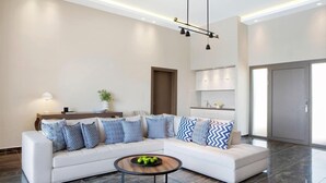 A modern living room with a sectional sofa, a coffee table, and a pendant light fixture.