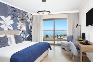 A hotel room with a bed, a desk, a chair, a television, and a balcony with a view. - Zeus Eleva Ajul, a Registry Collection Hotel (Kassandra)
