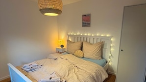 Ein Schlafzimmer mit einem Bett, einer Nachttischlampe und einer Pendelleuchte.