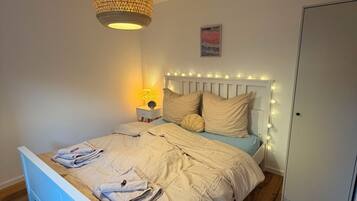 Ein Schlafzimmer mit einem Bett, einer Nachttischlampe und einer Pendelleuchte.