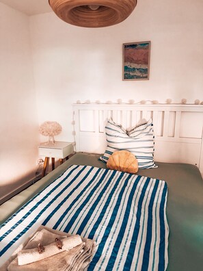 A bedroom with a bed, a bedside table, a lamp, and a painting on the wall. - CozyHome close to Luxemburg and Trier (Igel)