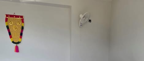 A reception desk with a modern design, a ceiling fan, and a wall-mounted fan.