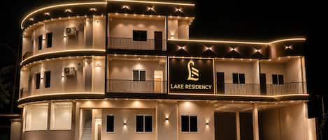 A multi-story building with balconies and a sign that reads 'LAKE RESIDENCY.'