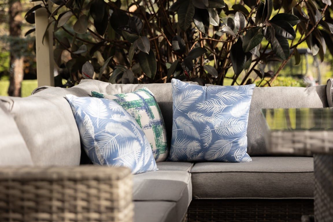 A sectional sofa with patterned cushions and a wicker chair.