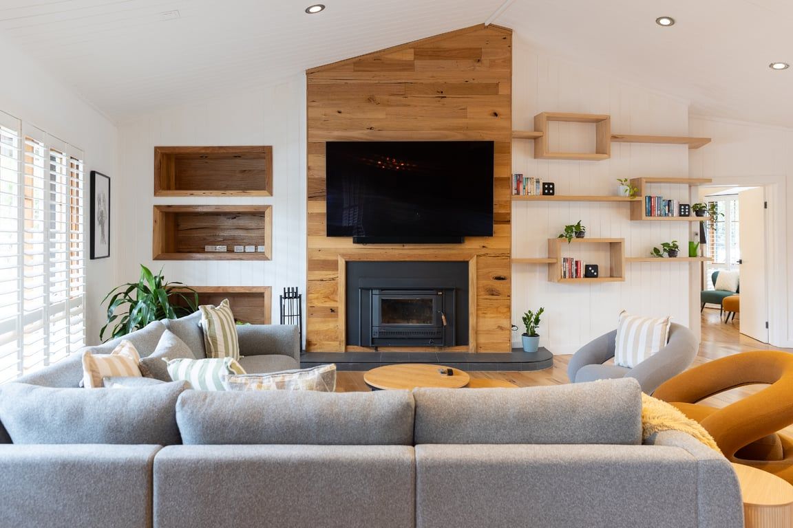 A modern living room with a fireplace, a flat-screen TV, and built-in shelving.