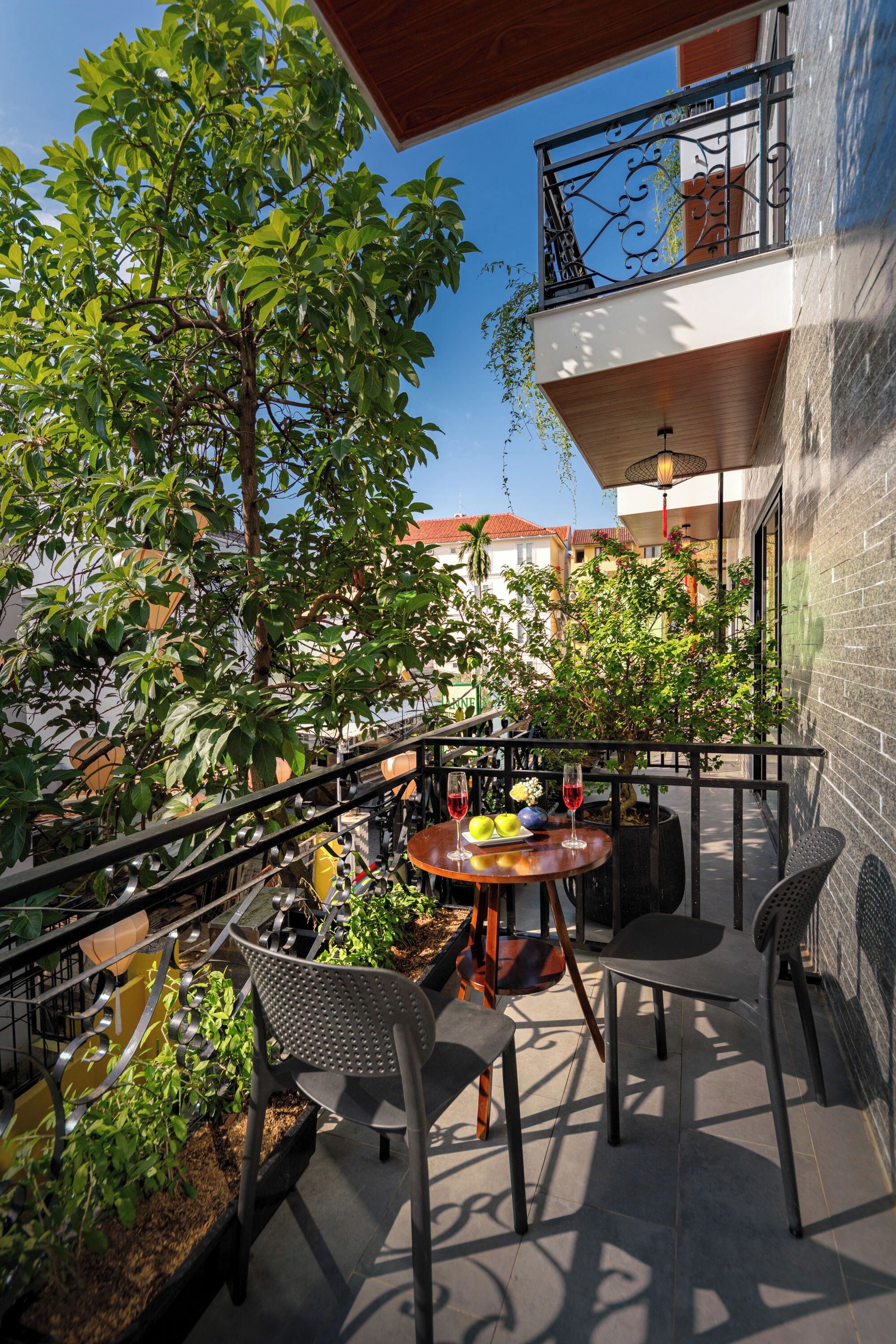 An outdoor patio with a table, chairs, and a railing.