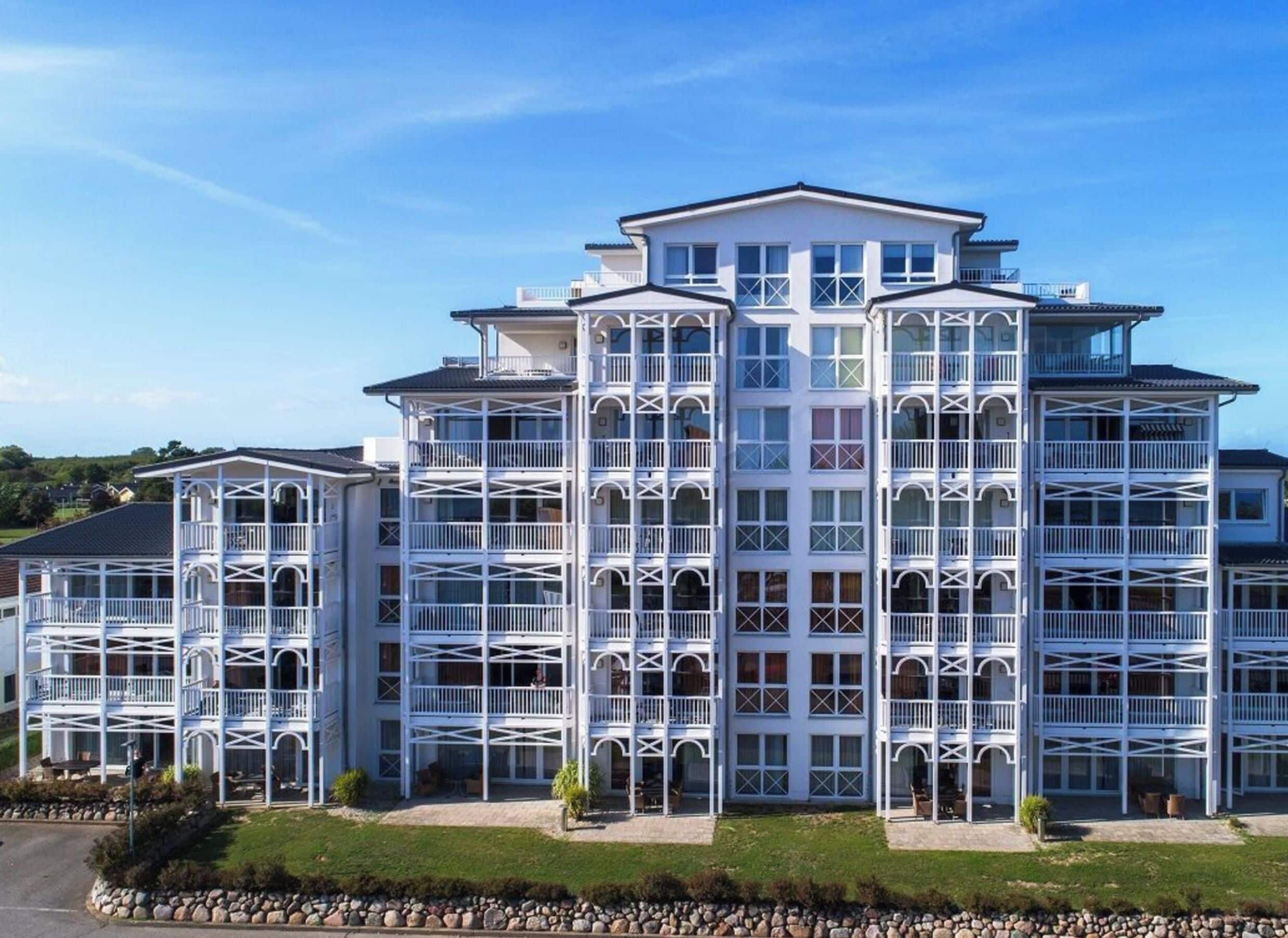 A multi-story hotel with a symmetrical facade, balconies, and a central entrance.