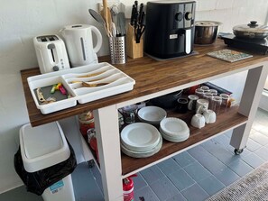 A kitchen counter with a coffee maker, toaster, and utensils.