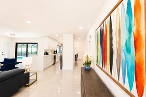 A modern living room with a sofa, a coffee table, and a painting. - Terra Nova at Delray Beach - Minutes To Beach & Atlantic Avenue (Delray Beach)