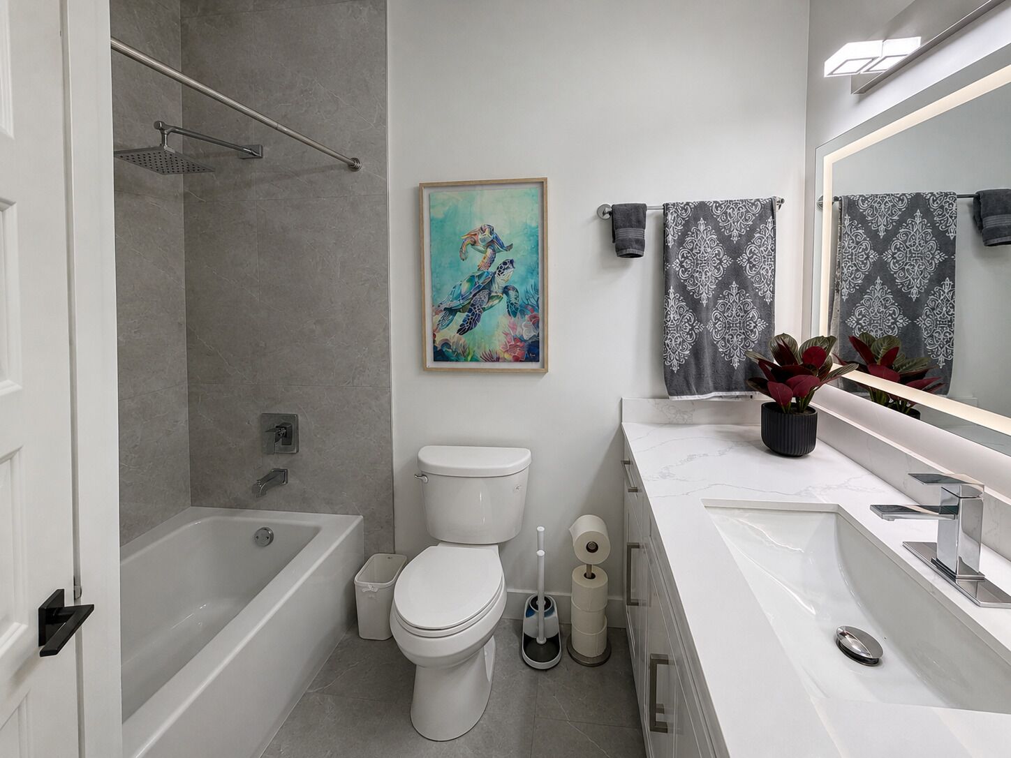 A modern bathroom with a bathtub, toilet, and sink.