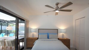 Une chambre à coucher avec un lit, des tables de chevet et un ventilateur de plafond.