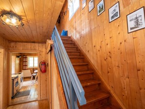A wooden interior with a staircase, a dining area, and a fire extinguisher.