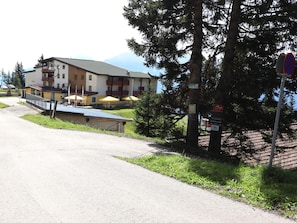 A hotel with outdoor seating and a mountain view.