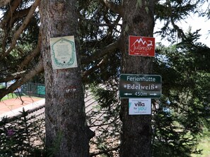 A signpost with directions to 'Ferienhütte' and 'Edelweiß' with a distance marker of 450m.