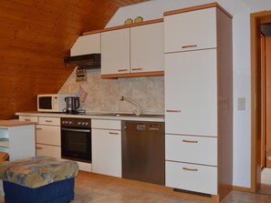 A compact kitchen with a microwave, stove, oven, and dishwasher. - Apartment in the Black Forest with a balcony (Schuttertal)