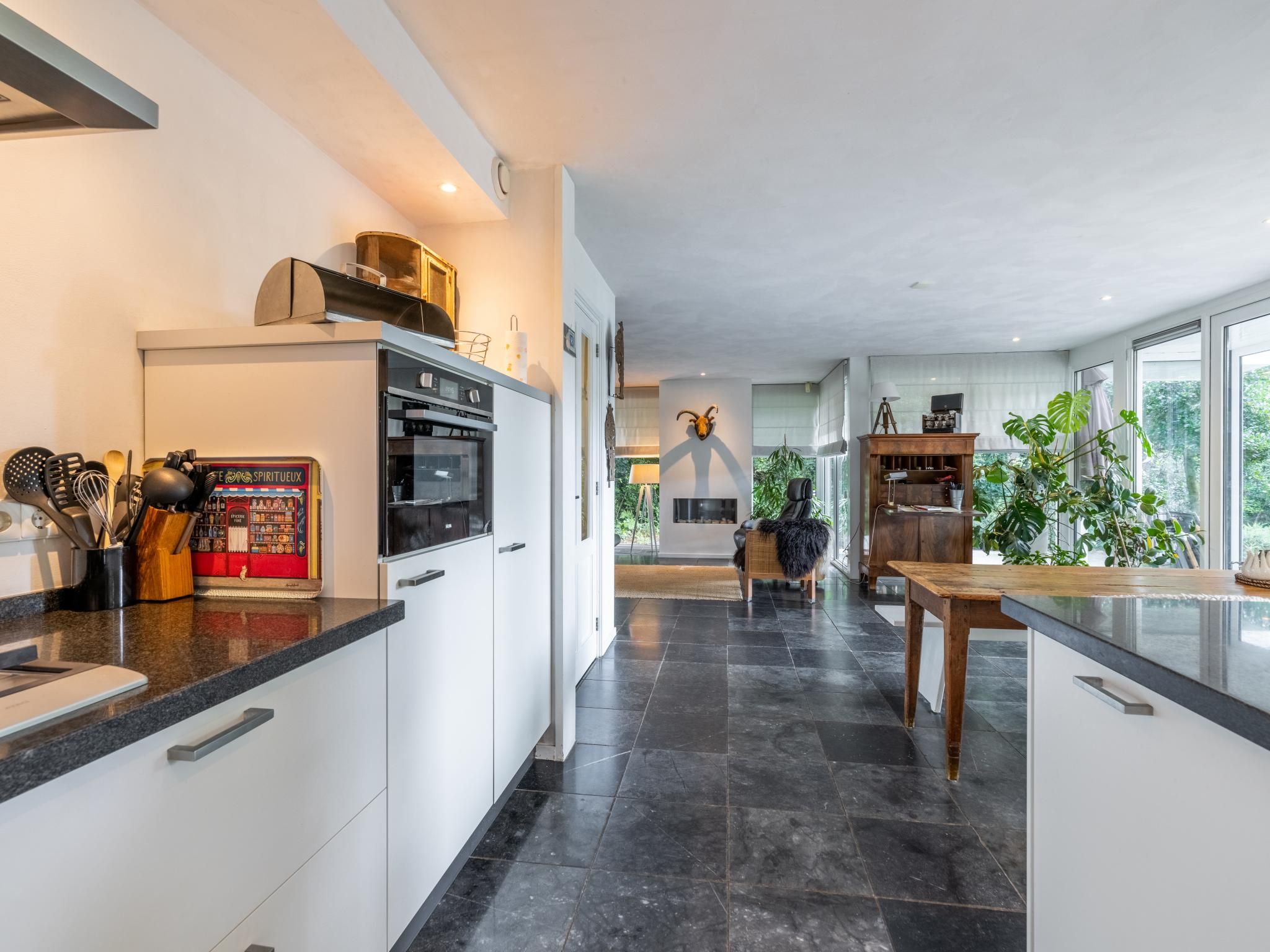 Una cocina moderna con horno integrado, cafetera y diversos utensilios de cocina.