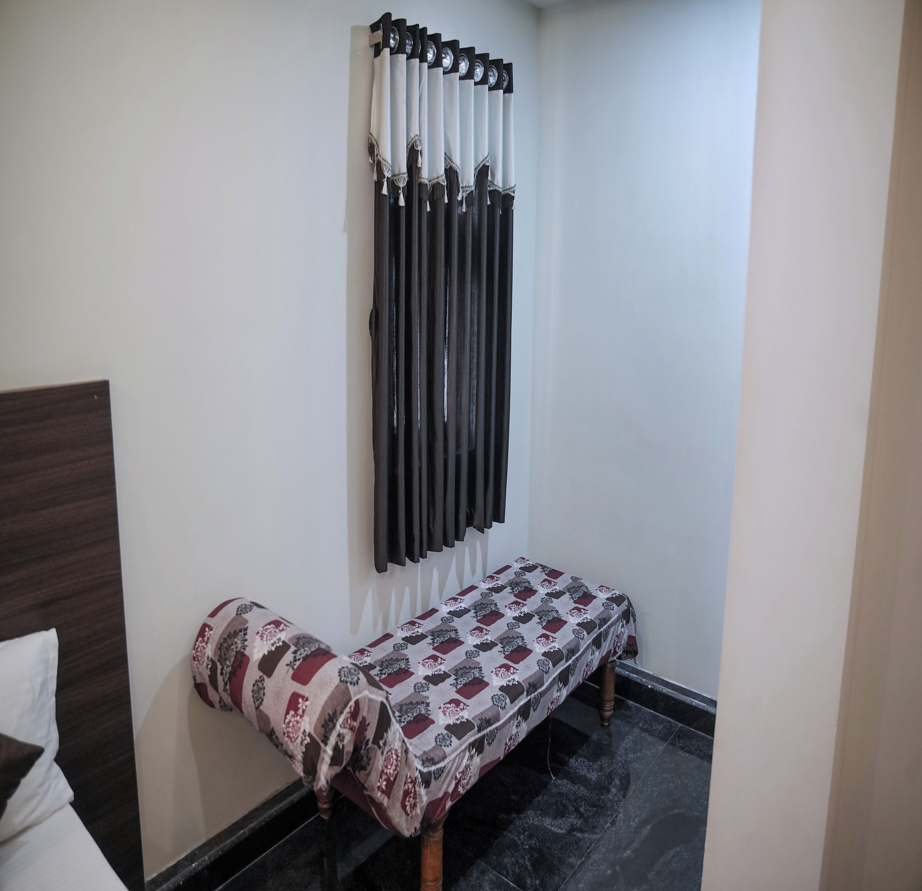 A room with a bed, a bench, and a wall-mounted radiator.